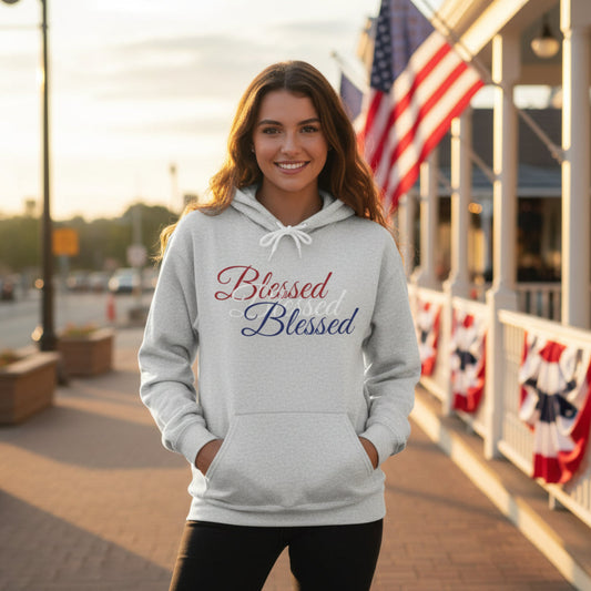 Woman wearing a gray hoodie with 'Blessed' text, standing outdoors with American flags in the background.