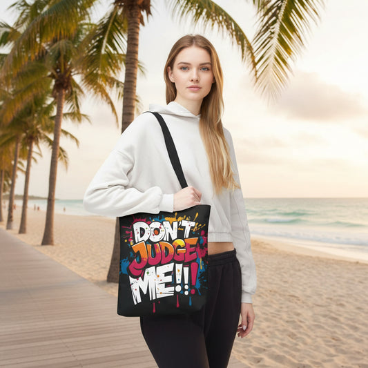 Woman holding a tote bag with 'Don't Judge Me' text on a beach