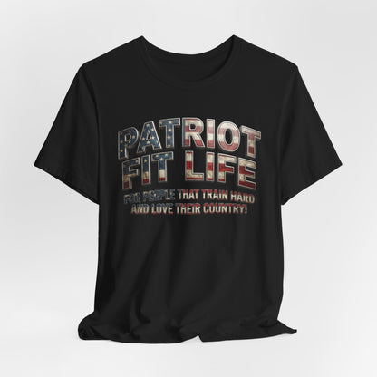 A black short-sleeve t-shirt with a distressed graphic on the chest reading 'PATRIOT FIT LIFE' in an American flag pattern and the slogan 'FOR PEOPLE THAT TRAIN HARD AND LOVE THEIR COUNTRY!' underneath, shown on a light gray background.