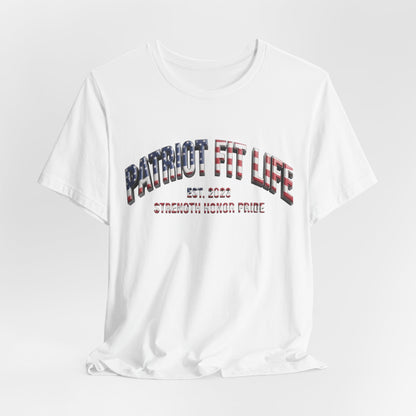 A white short-sleeve crewneck t-shirt with a graphic on the chest reading 'PATRIOT FIT LIFE EST. 2023 STRENGTH HONOR PRIDE' in a distressed red, white, and blue font, shown on a light gray background.