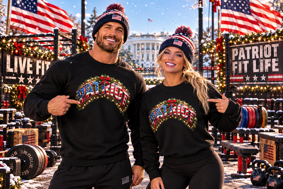A man and a woman pose together outdoors in matching black crewneck sweatshirts with a colorful 'PATRIOT' graphic across the chest, paired with matching beanie hats featuring American flag patterns. The background is a festive, snowy outdoor gym decorated with American flags, holiday lights, and banners.
