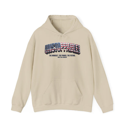 A beige pullover hoodie with a front kangaroo pocket and a graphic on the chest. The graphic features the word 'UNSTOPPABLE' in 3D block letters filled with an American flag pattern, with the text 'THE MINDSET.