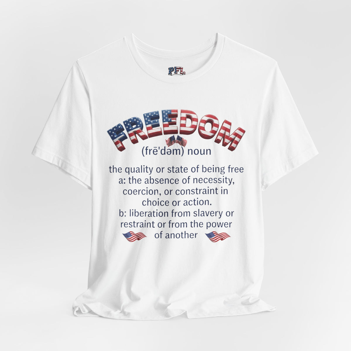 A white short-sleeve graphic t-shirt displayed on a light gray background. The front of the shirt features a dictionary-style definition of the word 'FREEDOM' filled with an American flag pattern, with the dictionary definition printed in black text below.