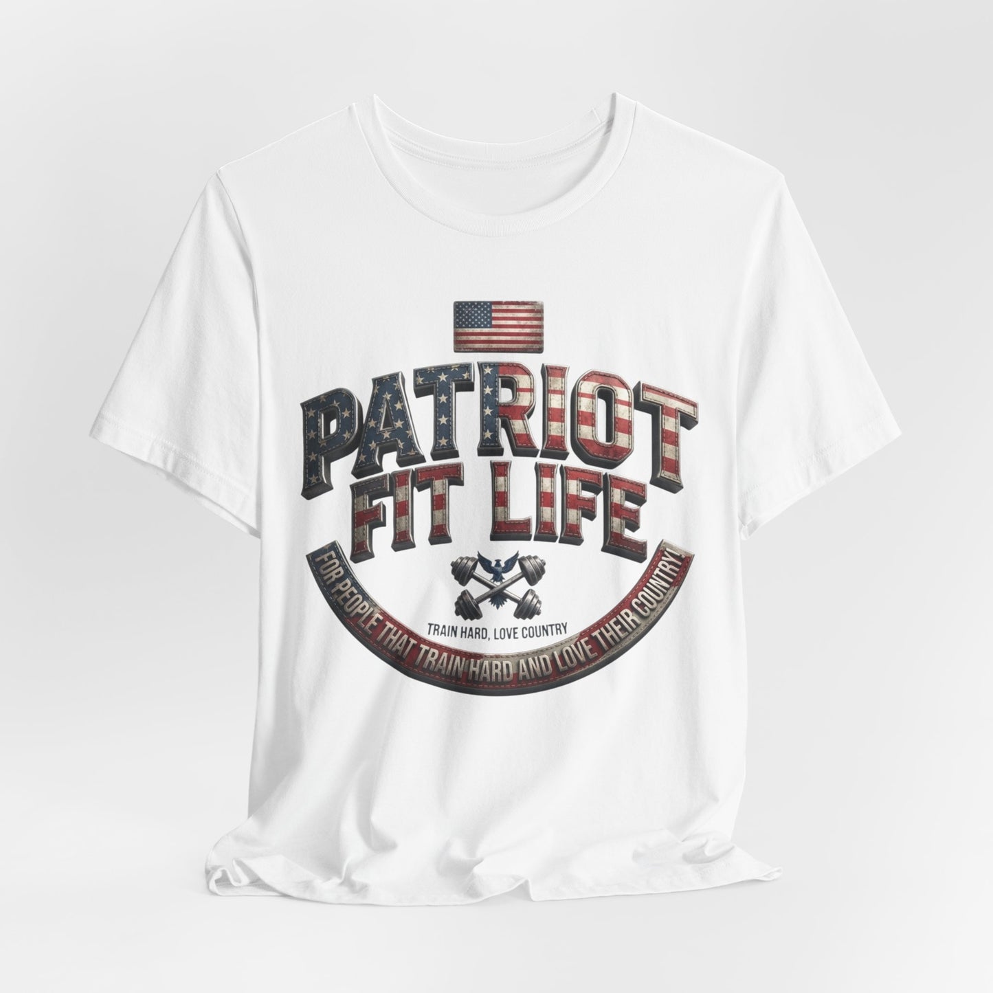 A white short-sleeve crewneck t-shirt with a patriotic graphic on the front. The graphic features the text 'PATRIOT FIT LIFE' in a distressed American flag pattern, an American flag, and a banner reading 'TRAIN HARD LOVE COUNTRY'.