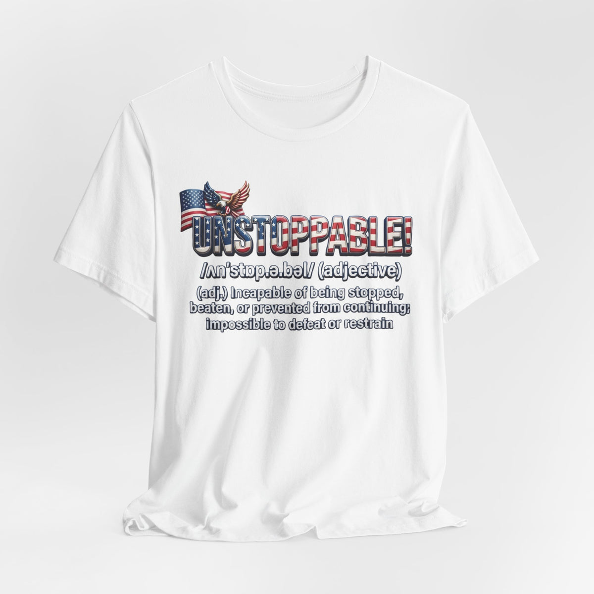 A white short-sleeve crewneck t-shirt with a graphic print on the front. The graphic features the word 'UNSTOPPABLE!' in a distressed red, white, and blue font, accompanied by a small American flag and eagle illustration, followed by a dictionary definition of the word 'unstoppable' in black text.