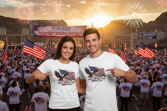 Two people wearing white t-shirts that say 1776-2026 Happy 250th Birthday America!!! with an eagle and American flag design in front of a crowd at the Hoover Dam and fireworks.