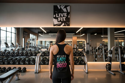 Woman in a gym wearing a tank top that says Act Like A Lady Lift Like A Boss! with the text 'LIVE FIT' on the poster on the wall.
