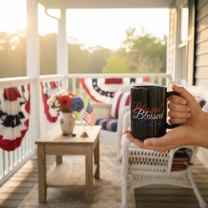 Person holding a mug with 'Blessed' text on a porch with American flags and flowers.
