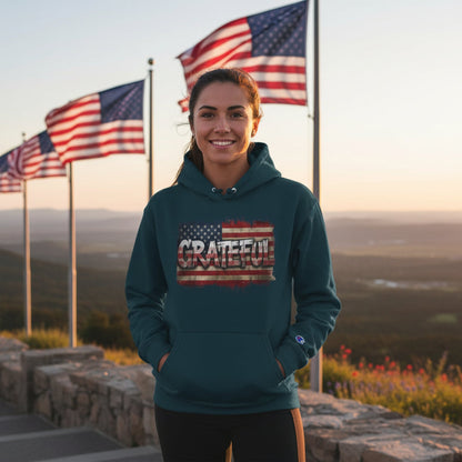 Woman wearing a hoodie with 'Grateful' design in front of American flags