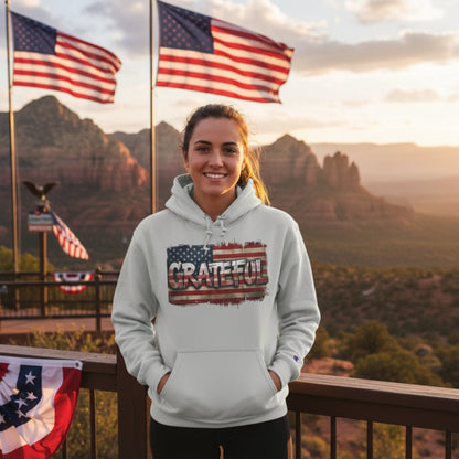 Person wearing a hoodie with 'GRATEFUL' text in front of American flags and a scenic background