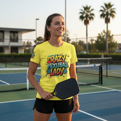 Woman wearing a yellow t-shirt with a 'Crazy Pickleball Lady' design on a pickleball court.