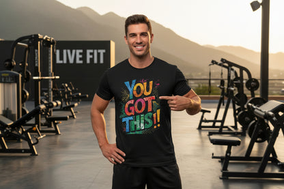 A man wearing a black t-shirt with colorful 'YOU GOT THIS!!' text with a LIVE FIT sign and mountains in the background.