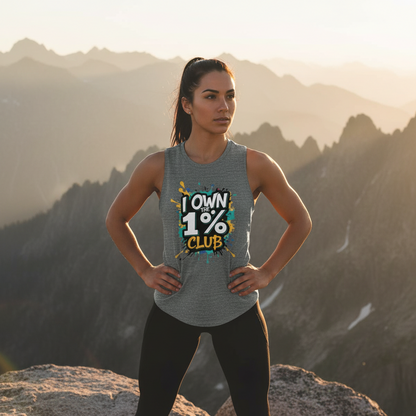 Woman wearing a gray tank top with the 'I Own the 1% Club' graphic design standing on a mountaintop.