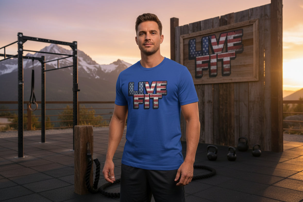 Man wearing a blue 'LIVE FIT' t-shirt in an outdoor fitness setting with mountains and sunset.