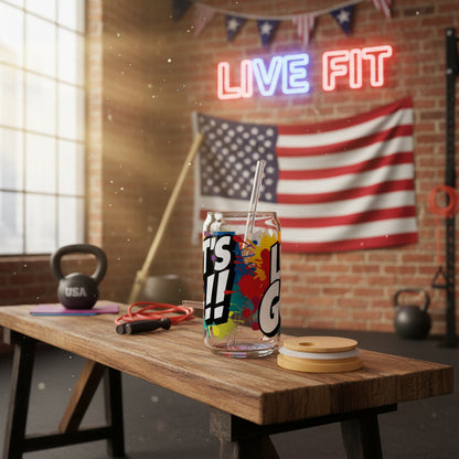 Colorful tumbler that says Let's Go!! with a straw on a wooden table in a gym setting with a 'Live Fit' neon sign and an American flag.