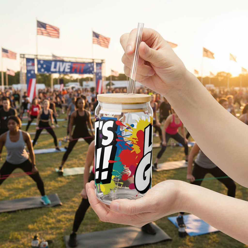 Hand holding a colorful jar that says LET'S GO!! with a straw against a sunset sky.