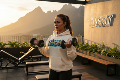Beige hoodie with 'LIVE FIT' graphic text in an outdoor gym with a mountain background.