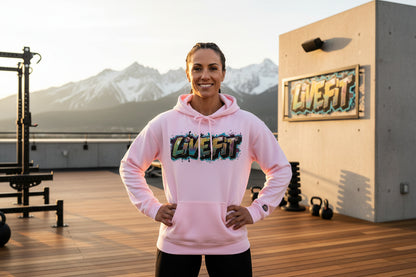 A woman wearing a pink hoodie with colorful 'LiVE FiT' branding in an outdoor fitness setting with mountains in the background.