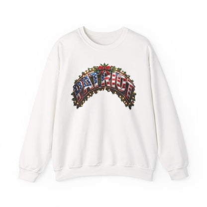 A white patriotic Christmas crewneck sweatshirt featuring a large graphic on the chest that reads 'PATRIOT' in an arched, American flag-themed design with red, white, and blue colors and green pine branches.