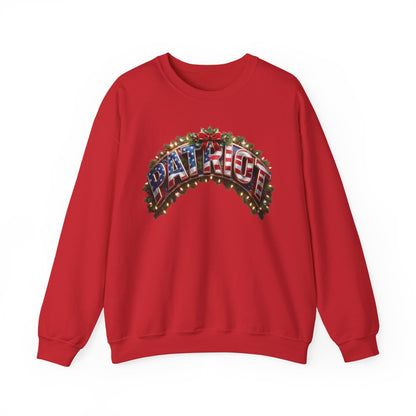A red crewneck sweatshirt featuring a festive graphic on the chest with the word 'PATRIOT' styled in an American flag pattern and decorated with Christmas lights and a red bow.