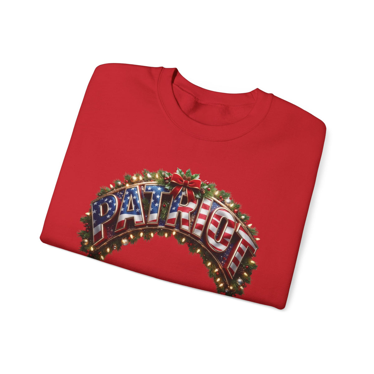 A folded red crewneck sweatshirt featuring a festive graphic on the front. The graphic displays the word 'PATRIOT' in 3D letters filled with an American flag pattern, framed by a green holly wreath with warm glowing lights and a red bow.