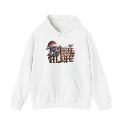 A white pullover hoodie with a festive Christmas graphic on the chest. The graphic features the words PATRIOT FIT LIFE in stacked red, white, and blue text, topped with a red Santa hat, and decorated with green pine branches.