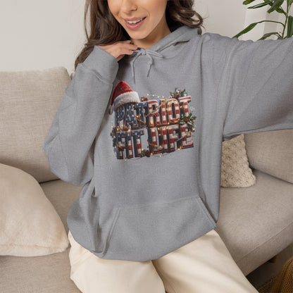 A woman wearing a gray pullover hoodie with a large festive 'PATRIOT FIT LIFE' graphic on the front.