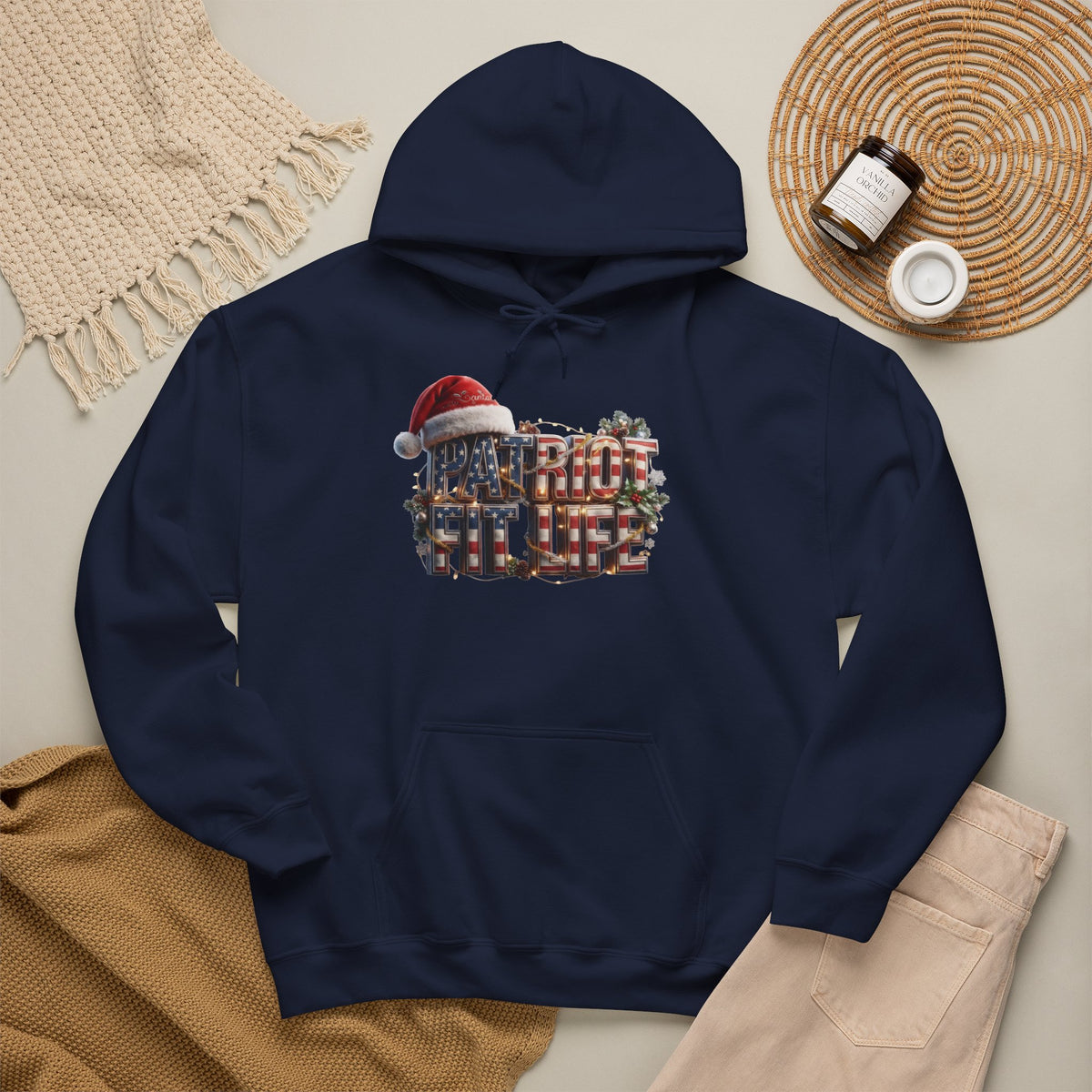 A navy blue pullover hoodie laid flat on a light beige surface, featuring a PATRIOT FIT LIFE Christmas-themed graphic with a Santa hat and holiday wreath. 