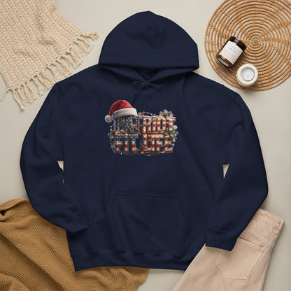 A navy blue pullover hoodie laid flat on a light beige surface, featuring a PATRIOT FIT LIFE Christmas-themed graphic with a Santa hat and holiday wreath. 