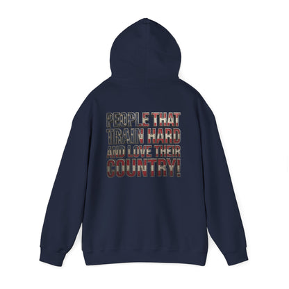A black pullover hoodie shown from the back, featuring a graphic text print that reads 'PEOPLE THAT TRAIN HARD AND LOVE THEIR COUNTRY!' in a distressed red, white, and blue plaid pattern.