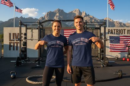 A man and a woman are standing together in an outdoor gym setting with mountains in the background, wearing matching navy blue t-shirts with 'PATRIOT FIT LIFE' text with an American flag pattern printed on the front.