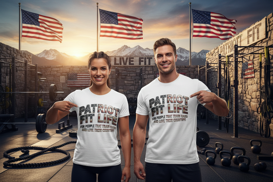 A man and a woman standing in a gym, both wearing matching white graphic T-shirts that read 'PATRIOT FIT LIFE' with smaller text that reads, 'FOR PEOPLE THAT TRAIN HARD AND LOVE THEIR COUNTRY!' underneath. The background shows a rustic gym setting with American flags, mountains, and workout equipment.