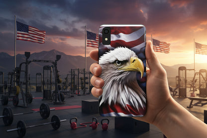 Person holding a phone case with a bald eagle American flag design in an outdoor patriotic gym setting.
