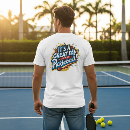 A man on a pickleball court wearing a white-colored t-shirt featuring an 'It's a Great Day To Play Pickleball!' text design.