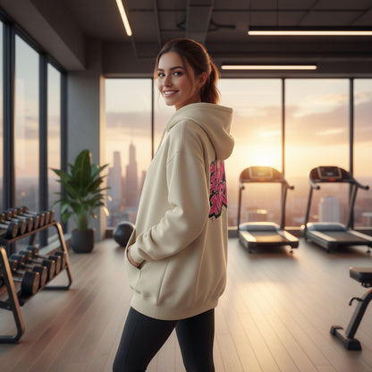 Beige hoodie with pink 'Gym Girl' text on the back against a scenic home gym background