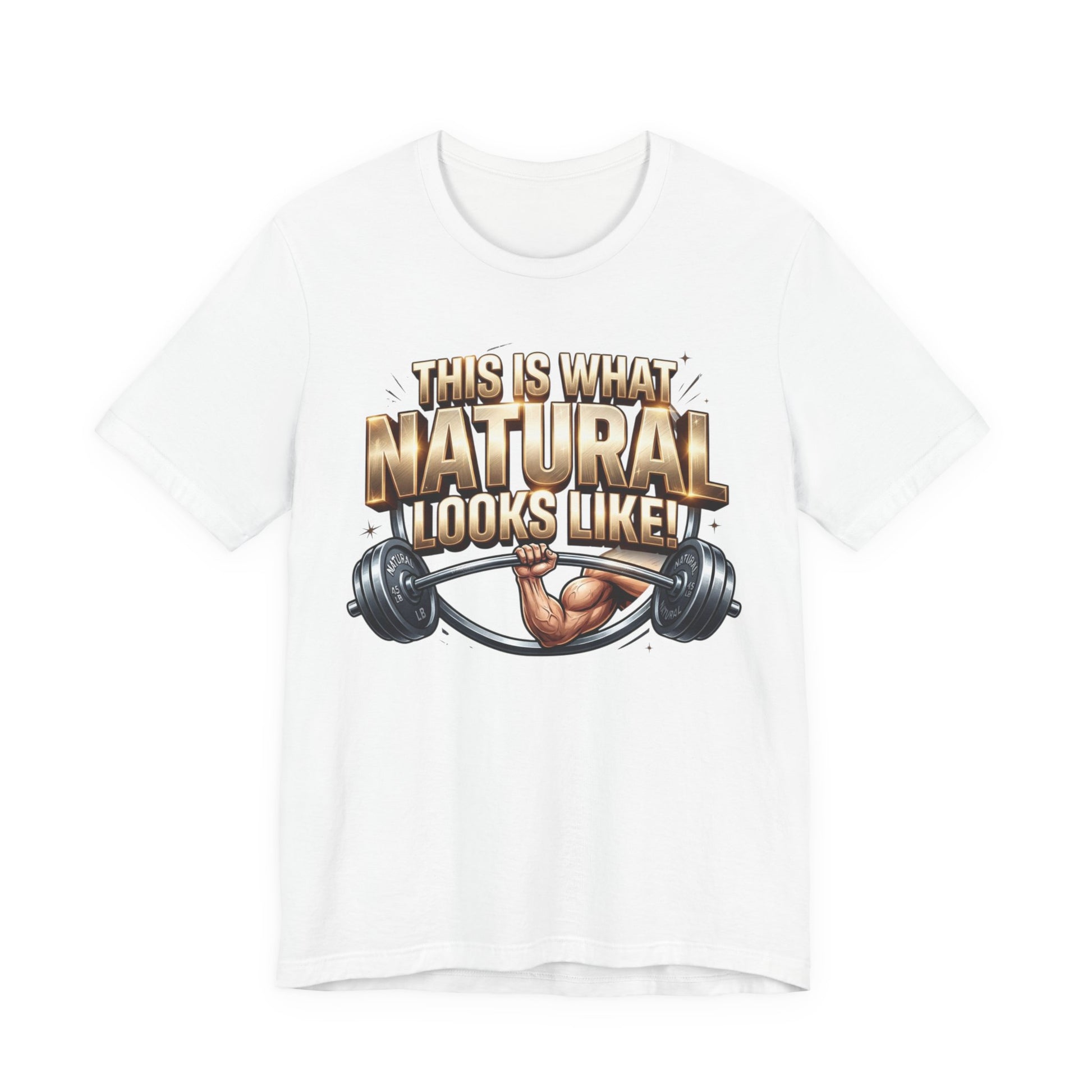 A white short-sleeve crewneck t-shirt featuring a graphic print on the front with the text 'THIS IS WHAT NATURAL LOOKS LIKE!' in a metallic gold font, above an illustration of a muscular arm lifting a barbell.