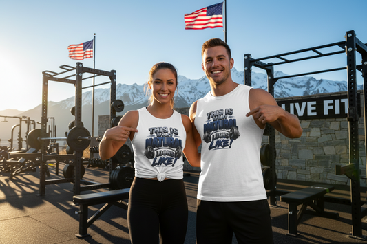 A white sleeveless muscle tank top featuring a graphic print on the front that reads 'THIS IS WHAT NATURAL LOOKS LIKE!' in stylized black, dark blue, and gray lettering with a barbell illustration.