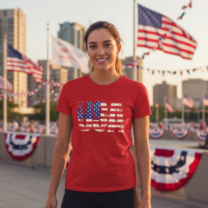 Woman wearing a red t-shirt with a U.S. flag design in an outdoor setting with American flags.