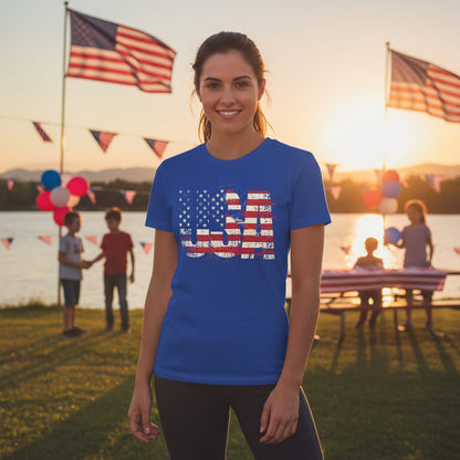 A woman wearing a blue t-shirt with a USA American flag design, standing outdoors with flags and balloons in the background.