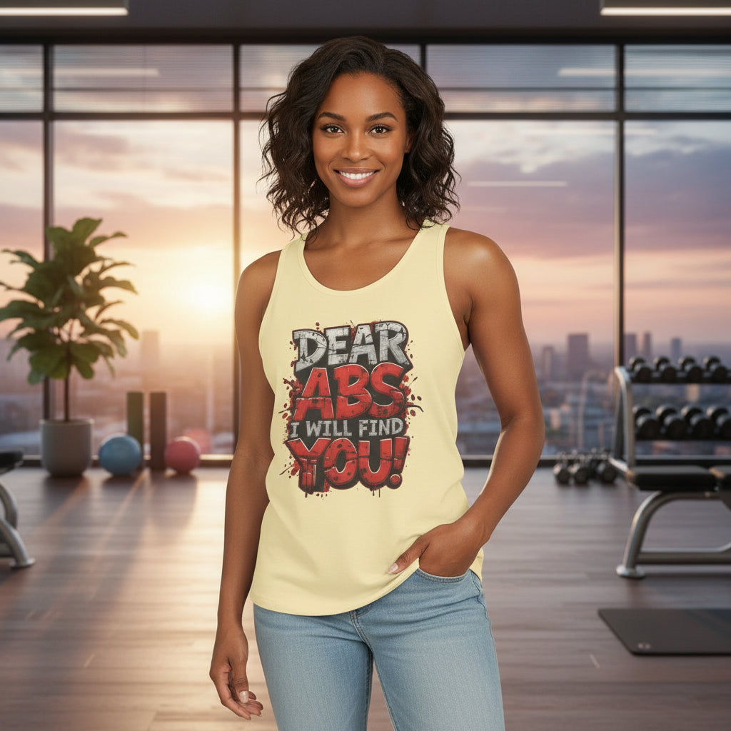 Woman wearing a tank top with a motivational message that says Dear Abs I Will Find You! in a scenic gym setting.