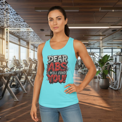 Woman wearing a light blue tank top with a humorous fitness slogan that says Dear Abs I Will Find You! in a gym setting.