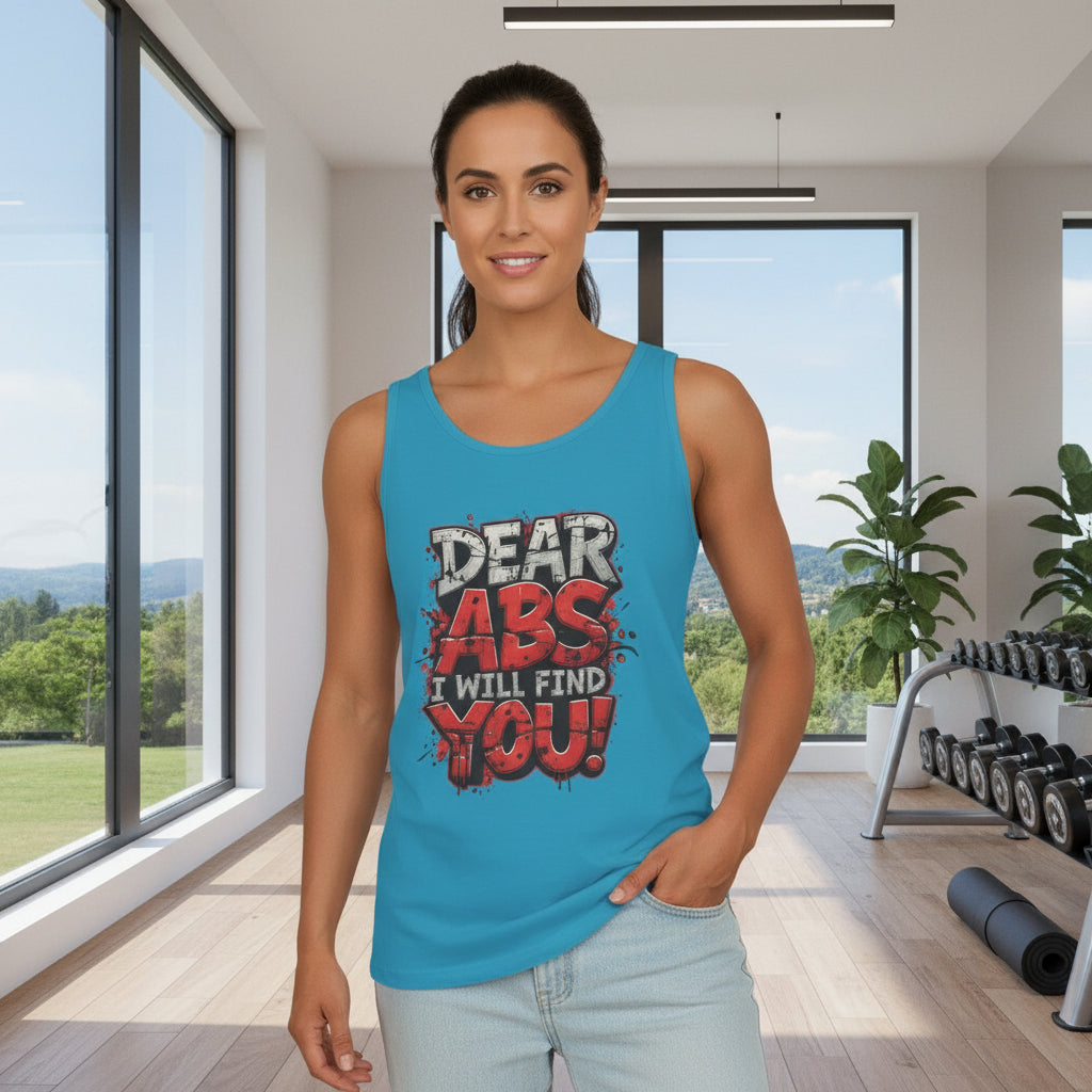 Woman wearing a blue tank top with a humorous message that says, Dear Abs I Will Find You! in a modern room.