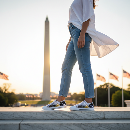 White sneakers with eagle and American flag design on a cobblestone street.