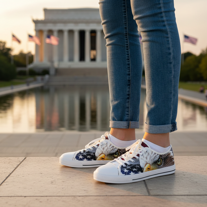 White sneakers with an American flag bald eagle design worn on a paved surface.