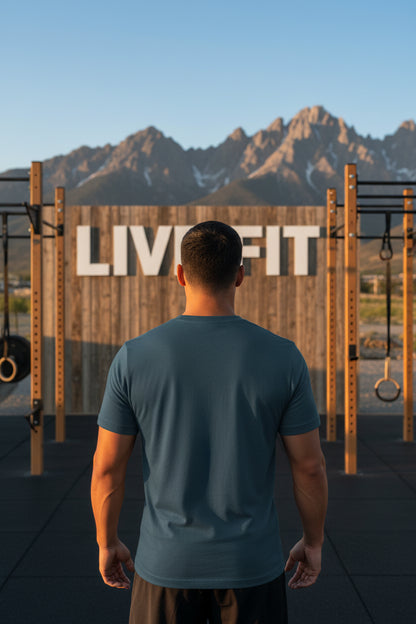 A man standing in front of a LIVE FIT outdoor gym with mountains in the background.