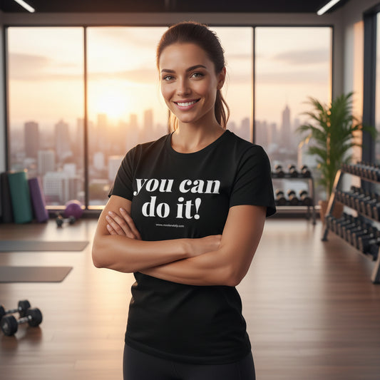 A female wearing a black t-shirt with 'you can do it!' text up against a gym background.